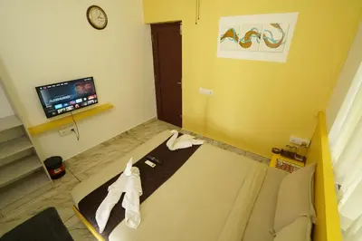 a living room with a couch and a tv at Twinn Waves By Atmos in Kozhikode