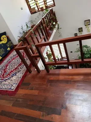 a room with stairs and a rug on a wooden floor at Shruthi's Aarohi-Nature's Retreat Homestay in Kannur