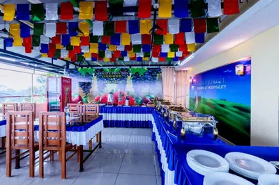 a restaurant with a blue table with chairs and colorful flags at Treebo Airsuite Airport Hotel in Cochin