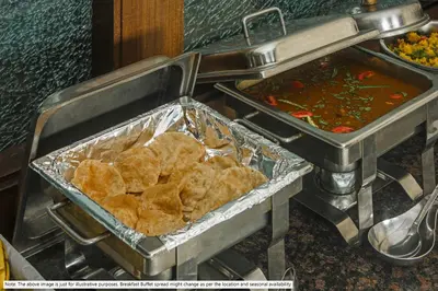 a table with two trays of food and a stove at Treebo Airsuite Airport Hotel in Cochin