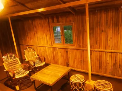 a wooden cabin with a wooden table and chairs at Merlys Fruit Garden in Cochin