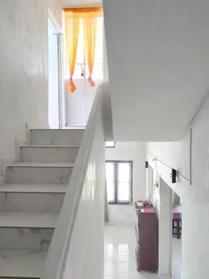 a staircase in a white room with a window at JK Home stay in Sultan Bathery