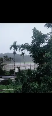 a view of a beach with palm trees in the background at JK Home stay in Sultan Bathery