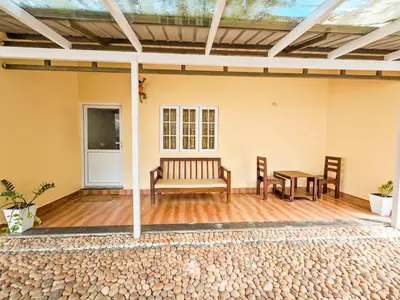 a patio with two benches and a table at Ibex Resorts, Valparai Mistly in Vālpārai