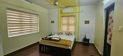 a bedroom with a bed and two windows at CASA DE CANOLI - A Private backwater villa in Kodungallūr