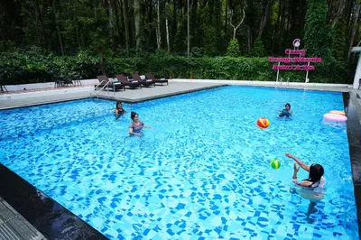 a group of children playing in a swimming pool at Coorg Orange Blossom Resort and Spa in Suntikoppa