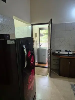 a kitchen with a refrigerator with flowers in it at Meadows Serene Retreat in Kannur