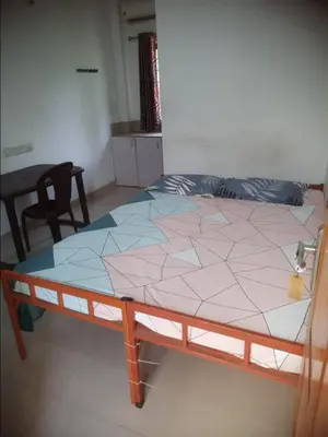 a bed in a room with a table and chairs at Kandengath Residency and Lodge in Mulagunnathukāvu