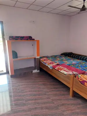 a bedroom with a bed and a shelf in it at GO2 Village Homestay in Pennāgaram