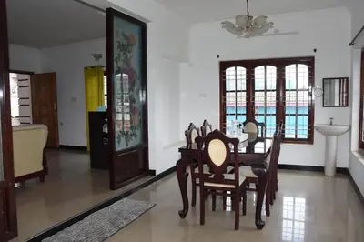 a dining room with a table and chairs at Elk Hill Palace in Ooty