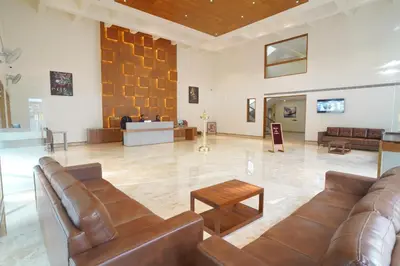 a lobby with brown leather couches and a table at Hotel Devalokam in Trittāla
