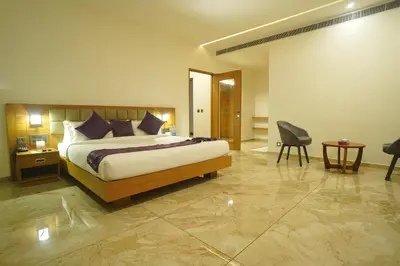 a bedroom with a bed and a desk and a chair at Hotel Devalokam in Trittāla