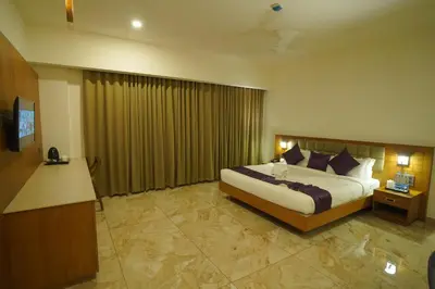a hotel room with a bed and a television at Hotel Devalokam in Trittāla