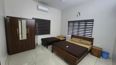 a bedroom with two twin beds and a mirror at Nambiaparambil Serviced Villa in Kakkayam
