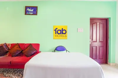 a room with a couch and a table and a door at Via Bala Garden in Ooty