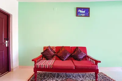 a red couch with pillows on it in a room at Via Bala Garden in Ooty