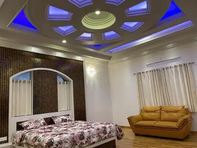a bedroom with a bed and a couch and a ceiling at The Misty Valley in Kodanād