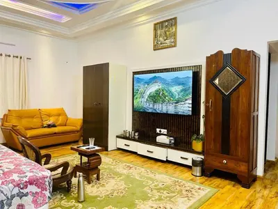 a living room with a couch and a television at The Misty Valley in Kodanād