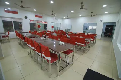 a dining room with tables and red chairs at PitStop21 in Athirappilly