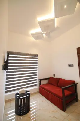 a living room with a red couch and a window at PitStop21 in Athirappilly