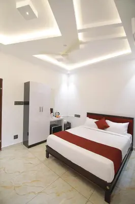 a bedroom with a large bed with red and white pillows at PitStop21 in Athirappilly