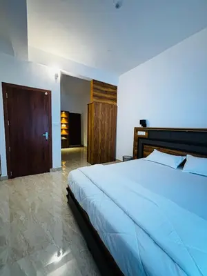 a bedroom with a large bed and a wooden door at casa wayn homestay in Sultan Bathery