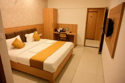 a hotel room with a bed and a desk at Bimba Hotels in Mysore