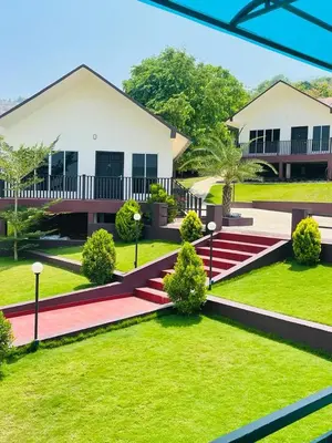 a house with a green yard with a red pathway at Whiteflower Mountain Resort in Perintalmanna