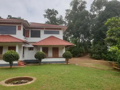 a house with a lawn in front of it at Tropical Blooms by StayApart in Kutta