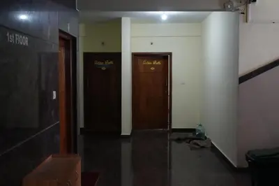 a hallway with two wooden doors in a building at Golden Bells in Vānivilāsa Puram