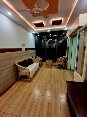 a room with a couch and chairs on a wooden floor at Nagadeep Residency in Mysore