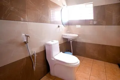 a bathroom with a toilet and a sink at Nagadeep Residency in Mysore