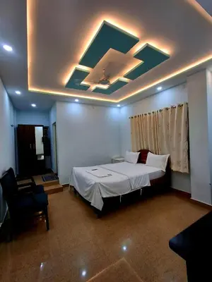 a bedroom with a large bed and a ceiling at Nagadeep Residency in Mysore