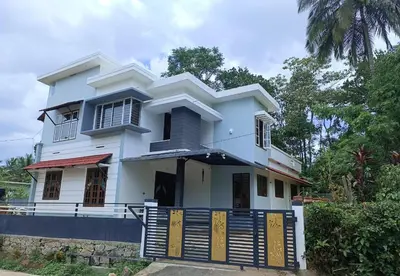 a white house with a gate in front of it at Aditi HOMESTAY in Kalpetta