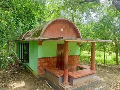 a small brick and green building with a roof at Sradha Farm Stay - Kollengode in Kollengode