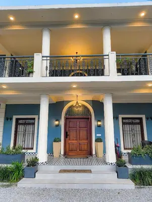 a house with a wooden door and a balcony at Villa Forever Coorg in Madikeri