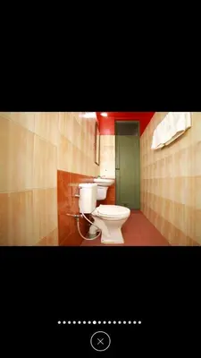 a bathroom with two toilets and a green door at Raahath Inn Munnar in Munnar