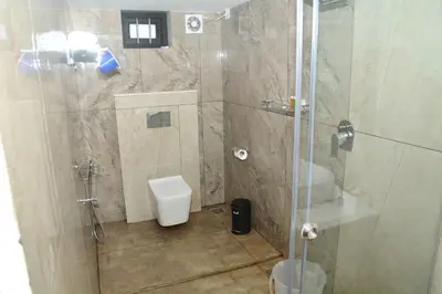 a bathroom with a shower and a toilet at Orange Valley Farm Resort in Munnar