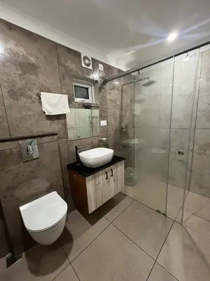 a bathroom with a toilet and a sink and a shower at Orange Valley Farm Resort in Munnar