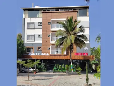 a building with a palm tree in front of it at Dkgardenia24 in Kanakapura