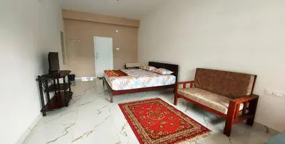 a bedroom with a bed and a chair and a rug at Hornbill Castle in Vālpārai