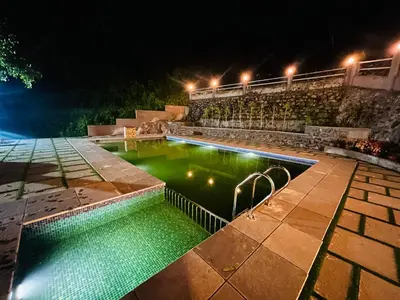a swimming pool with green water at night at Brooke hills falls view in Vallikavungal