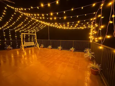 a patio with lights and a chair on it at Brooke hills falls view in Vallikavungal