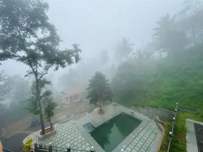 a house in the fog with a swimming pool at Brooke hills 2 BHK villa falls view in Vallikavungal