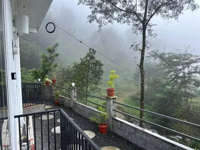 a balcony of a house with a view of a mountain at Brooke hills 2 BHK villa falls view in Vallikavungal