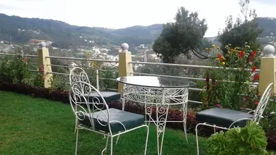 a table and chairs sitting on top of a garden at Wyoming Heritage in Ooty