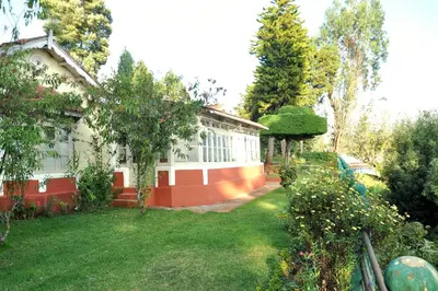 a house with a green yard with a yard at Wyoming Heritage in Ooty