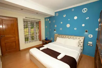a bedroom with a bed with a blue wall at Lazo Silver Lake , Ooty in Ooty