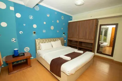 a bedroom with a bed with a blue wall at Lazo Silver Lake , Ooty in Ooty