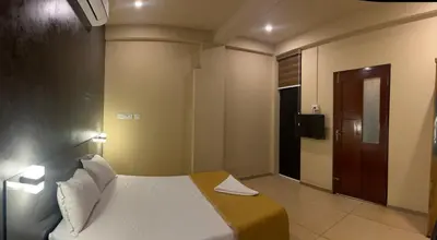 a small bedroom with a bed and a door at Rocks beach house in Kannur